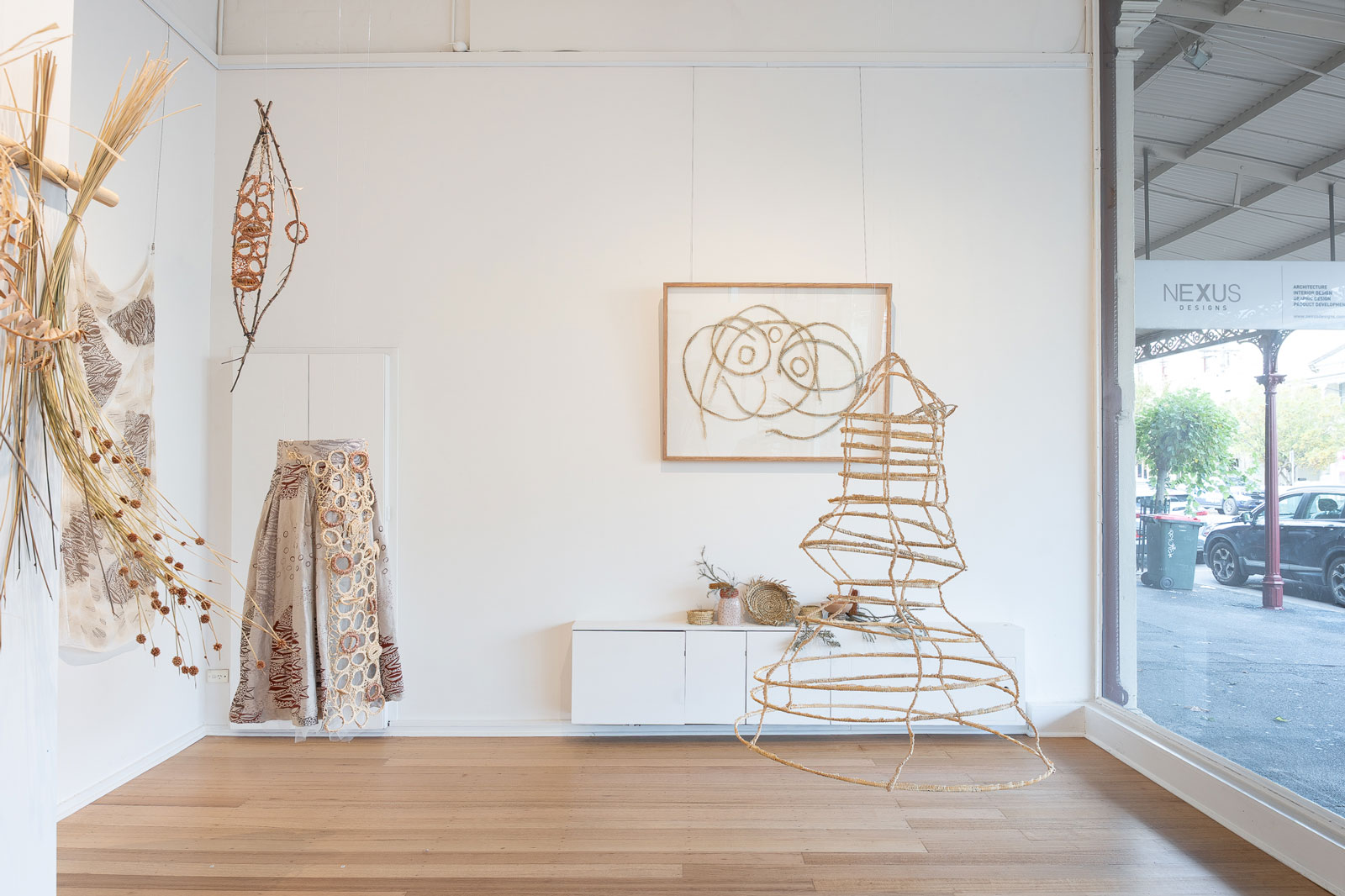 a gallery space, filled with woven natural materials 