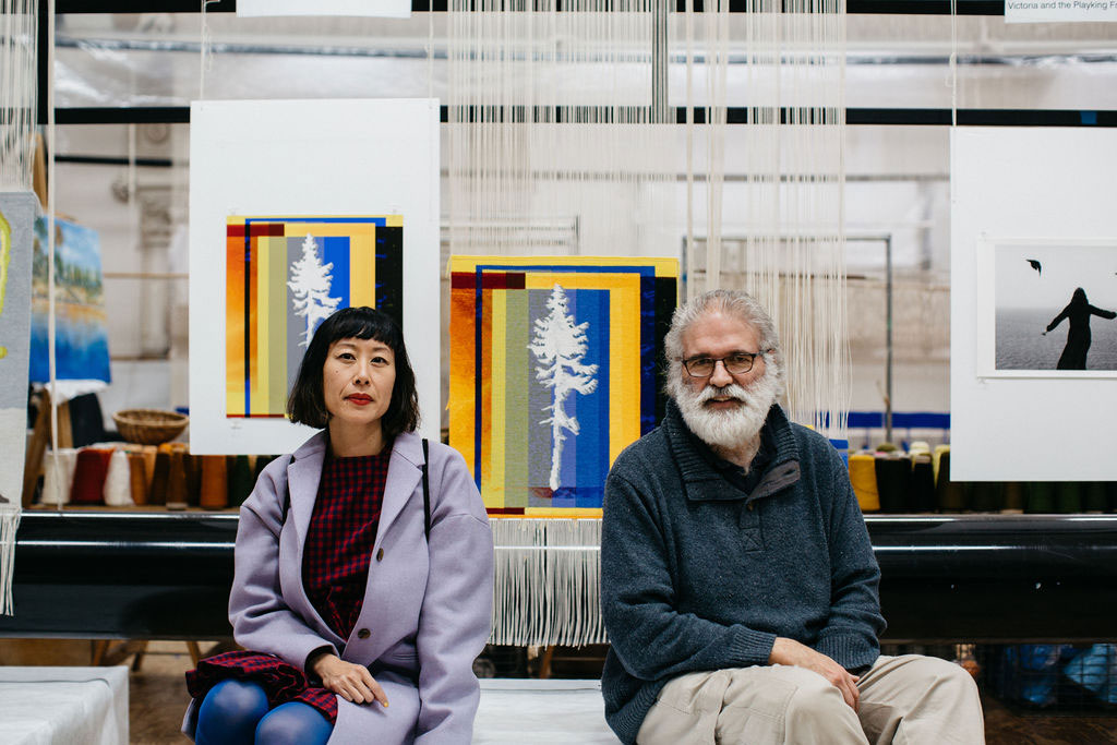 Eugenia Lim and Tim Gresham in front of the 'Fossil Futures (Old Tjikko)' tapestry, designed by Eugenia Lim in 2021. Photograph courtesy of Marie-Luise Skibbe.