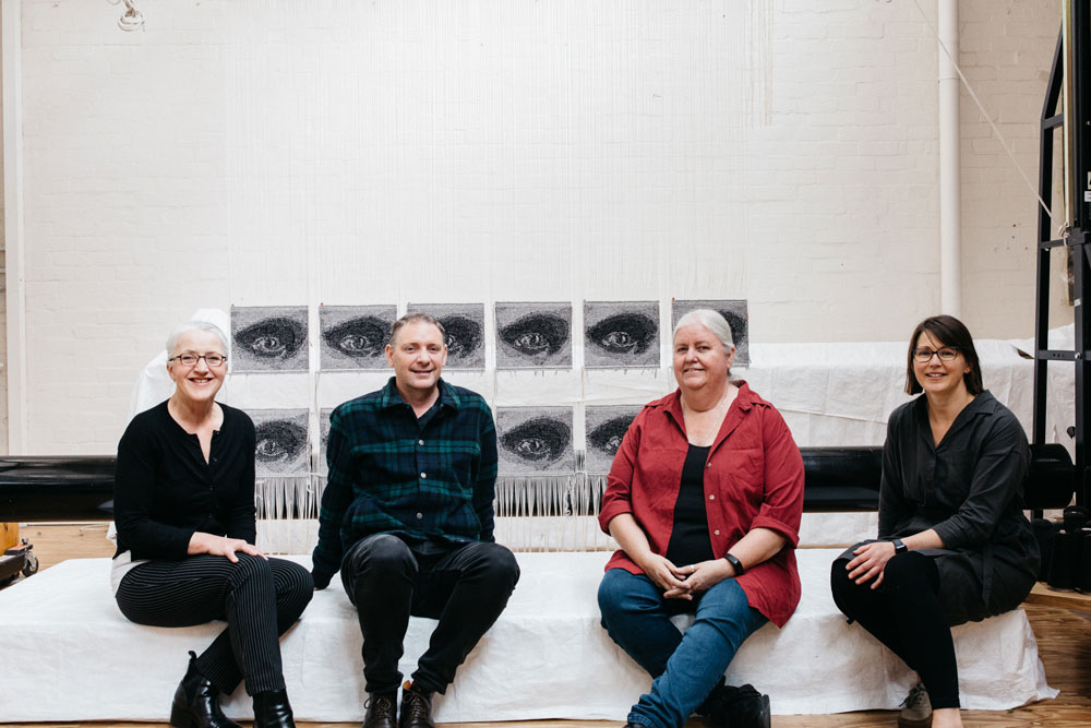 Artist Brook Andrew with weavers Pamela Joyce, Chris Cochius & Karlie Hawking in front of the 'Miili' edition. Photo by Marie-Luise Skibbe. 