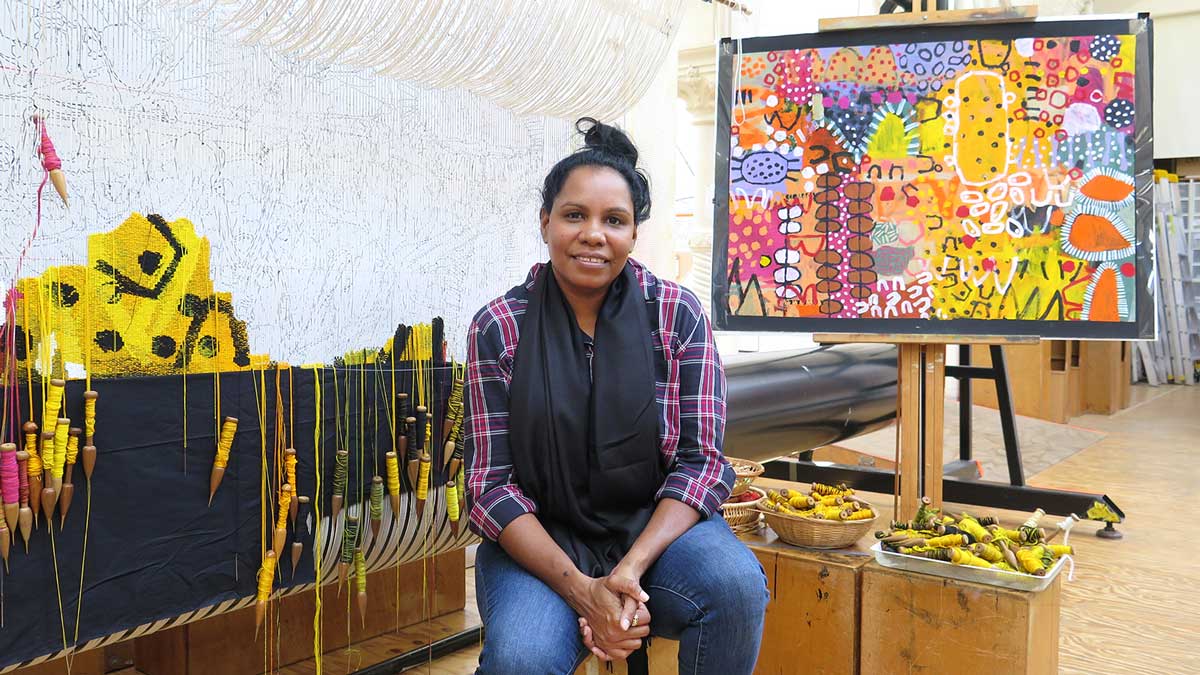 Artist Naomi Hobson in front of her design for 'The Royal Harvest' tapestry at the Australian Tapestry Workshop in 2021. Photo: ATW. 